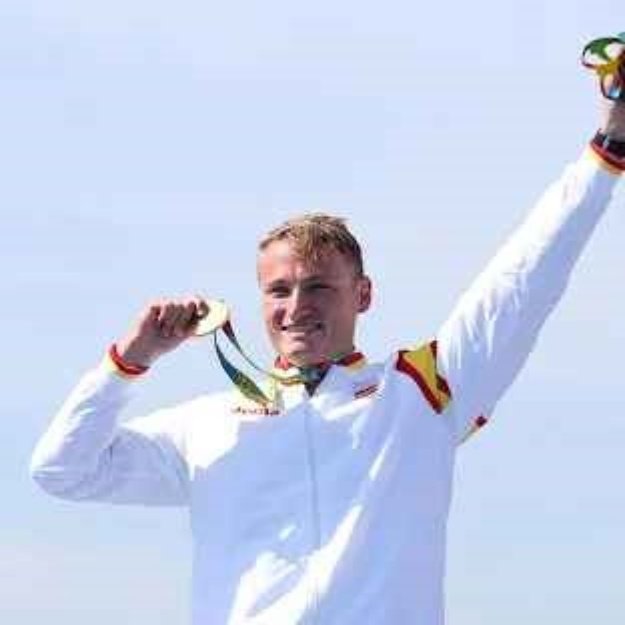 Foto de Marcus Cooper, medallista olímpico mostrando una medalla de oro