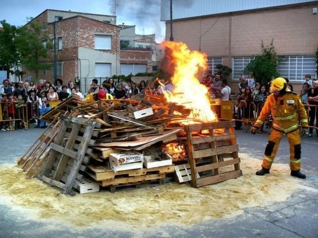 Bombero controlando como arde una hoguera en la calle en el 'Dia del Ros'