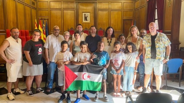 El alcalde, el vicealcalde y la concejala de infancia posan en el Salón de Plenos con los 5 menores y las familias de acogida