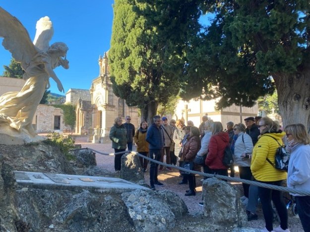 Participantes de la visita guiada al cementerio atendiendo las explicaciones del guía