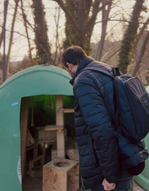 Persona observando el antiguo iglú en cuyo interior hay una torre de juegos y rascador de madera para gatos