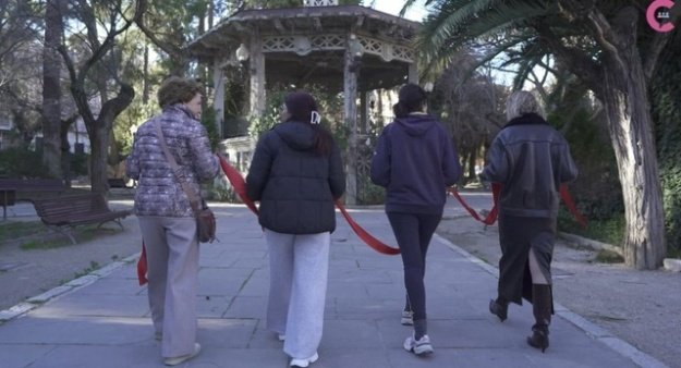 Captura del video del Consell Social en el que se ve a cuatro mujeres de espaldas sosteniendo una cinta roja
